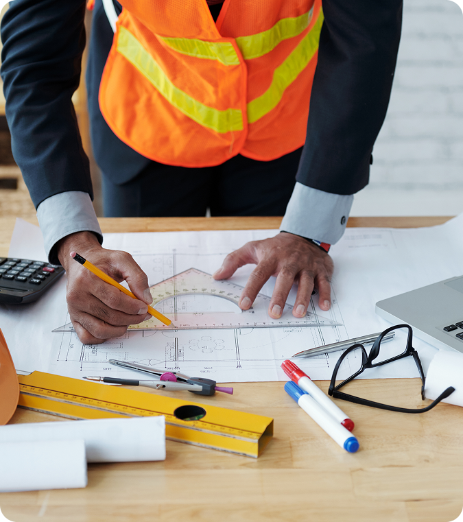 Estimator reviewing blueprints at a desk