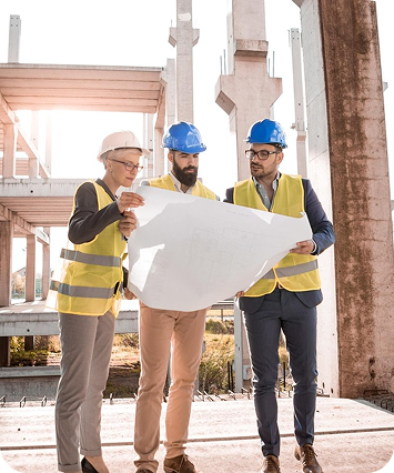 Construction team reviewing blueprints on site