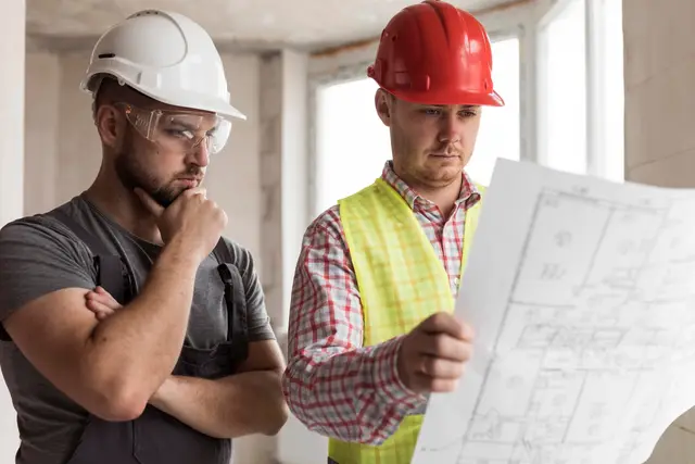 Construction professionals reviewing a building model and plans